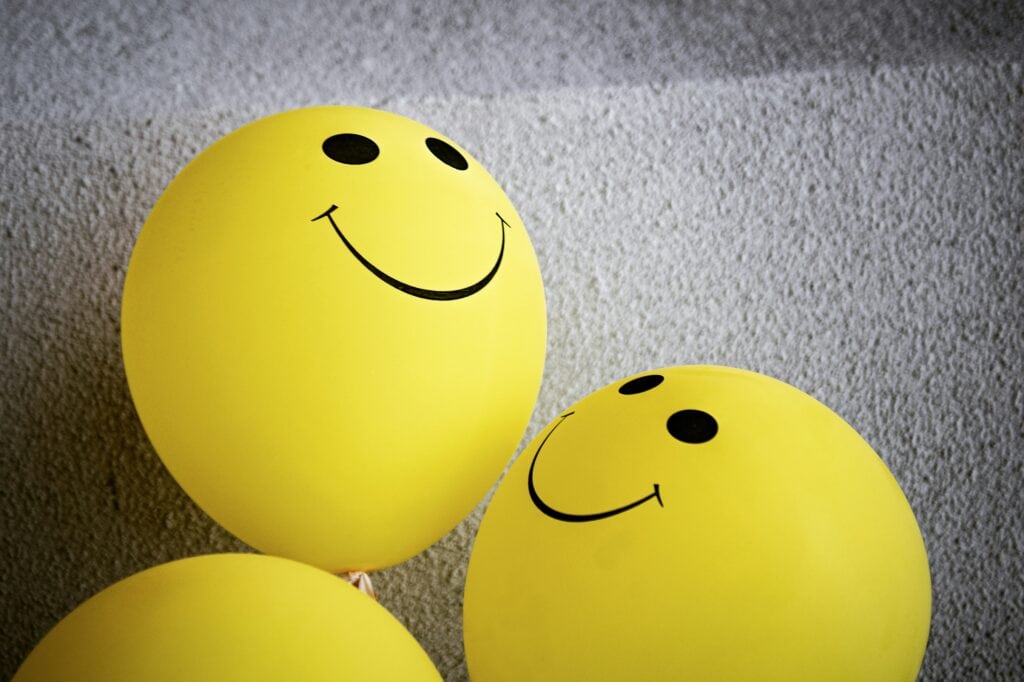 Alt text: Bright yellow balloons with smiley faces representing happiness, positivity, and mental wellbeing, ideal for promoting mindful learning and mental health awareness.